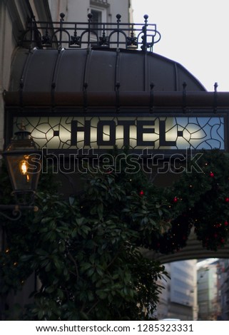 Glowing Hotel Sign - Hotel Sign with Building and Trees and Bushes
