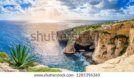 Blue Grotto, Malta. Natural stone arch and sea caves and agave plant in foreground. Phantastic sea view on Malta island. Royalty-Free Stock Photo #1285396360