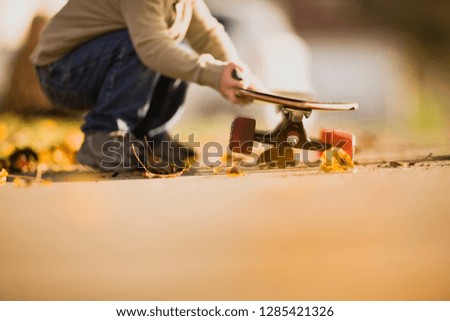 Man bending over holding skateboard.