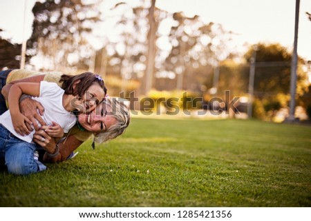 Girl and grandmother playing on grass in park