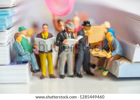 Miniature toy of passengers read newspaper and people travel from work on a public transport concept - travel on a train or bus.