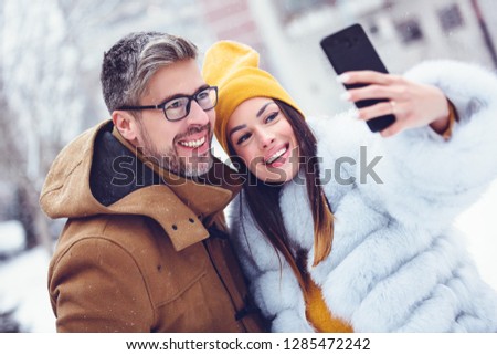Happy friends couple taking selfie by smartphone, wintee time, Lifestyle concept