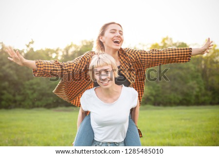 Two cheerful young women having fun outdoors. Best friends