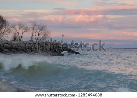 Toronto City skyline at the sunset with pink clouds, windy winter spring cityscape over lake Ontario,