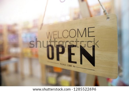 Wooden sign board hanging on door of shop cafe, we are open.