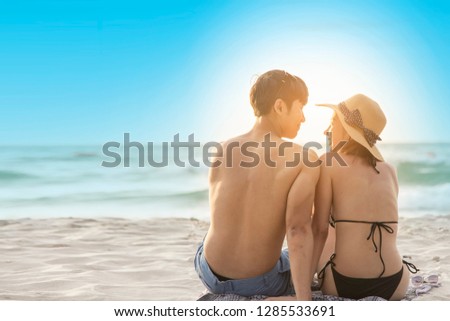 Cheerful couple having some good time naked on the beach