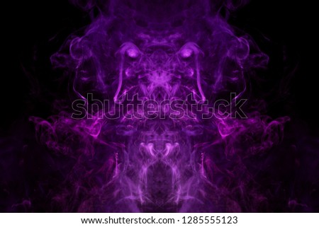 Dense multicolored smoke of  pink and purple colors in the form of a skull, monster, dragon on a black isolated background. Background of smoke vape. Mocap for cool t-shirts
