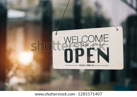 "Open" on cafe or restaurant hang on door at entrance.