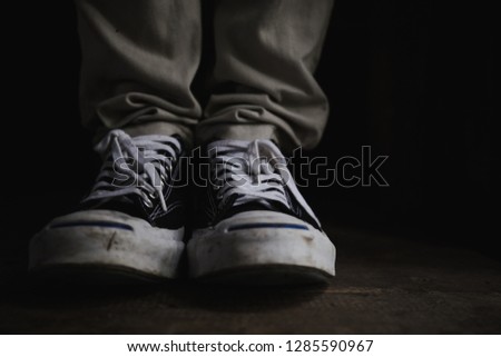 leg woman wear black and white sneakers and jean .with copy space for text.stylish and people in street urban fashion.accessories men and women wear shoes concept.dark tone
