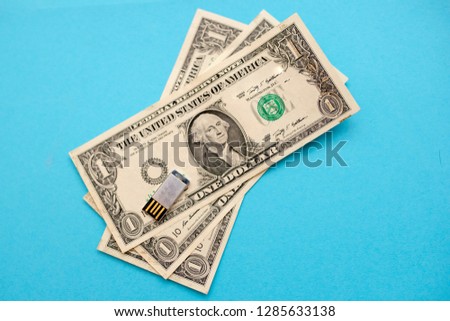 One dollar and usb memory isolated on a blue background