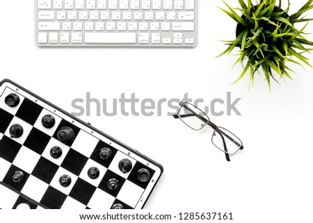 Chess as symbol of business competition. Chess board with figures near computer keyboard on white work desk top view