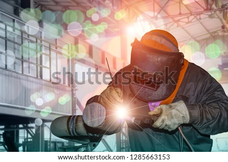 welder man, Industrial Worker at the factory welding process by Tig gas argon close up with protective equipment mask, PPE marks welder on bokeh background.