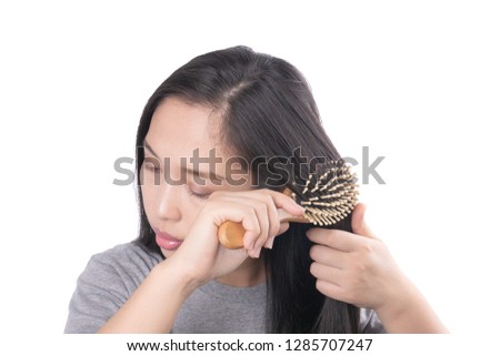 Adult Asian women serious with hair problem holding comb and hair split ends on hand. hair loss problem and Hair treatment concept
