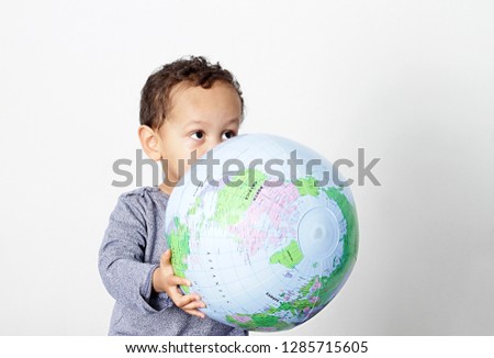 little boy holding globe on earth day smiling with white background stock photo
