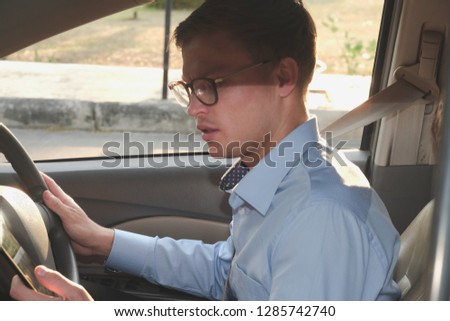 businessman use app on smartphone in car. caucasian man holding mobile phone checking direction while driving