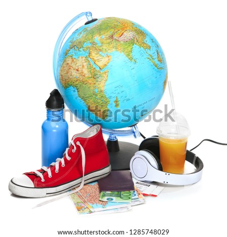 The blue globe, sneakers, thermos and headphones on white background. The travel, tourism and holidays concept