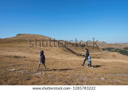 woman with two children walking in field in Transalpina