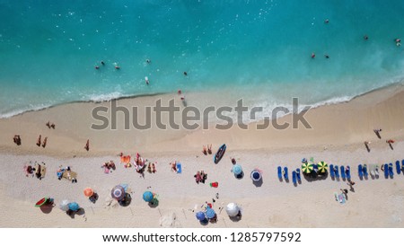 Aerial top view photo of paradise organised sandy turquoise beach with umbrellas and sunbeds located in Ionian island, Greece