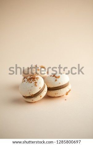 Creamy macarons close-up on beige background