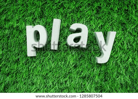 Play from made from concrete alphabet top view on green grass