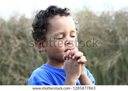 child praying to God with hands held together stock image and stock photo