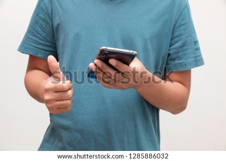 Man showing thumbs up and another hand holding smartphone on white background.