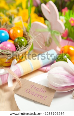  Easter eggs and tulips on wooden planks .German text Happy Easter. Easter background.