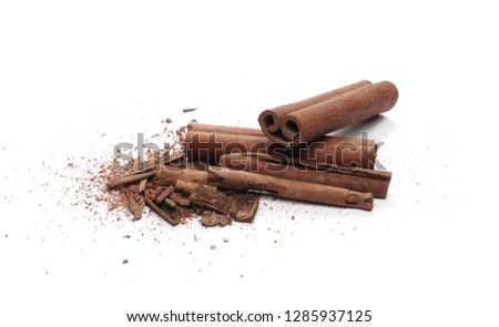 Cinnamon sticks with powder and shavings, macro isolated on white background