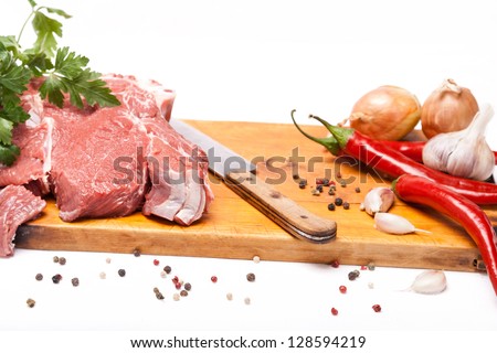 fresh meat of beef with bone on wooden with spices and knife