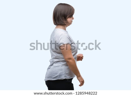 Young adult woman with down syndrome over isolated background looking to side, relax profile pose with natural face with confident smile.