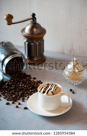 cup of coffee with whipped cream and beans