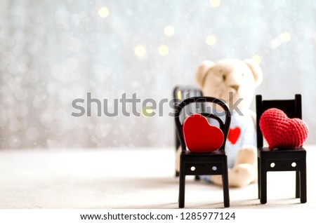 Creative holiday image with copy space. Two black chairs with wooden and knited heart, teddy bear and fairy-lights on a background. St Valentine's day romantic concept Royalty-Free Stock Photo #1285977124