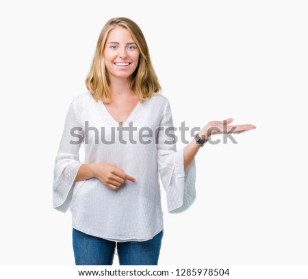 Beautiful young elegant woman over isolated background smiling cheerful presenting and pointing with palm of hand looking at the camera.