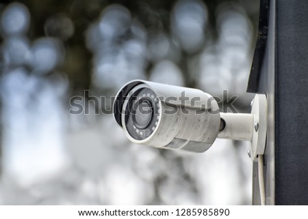 Security system of outdoor video surveillance, CCTV Security Camera on blurred outdoors background.