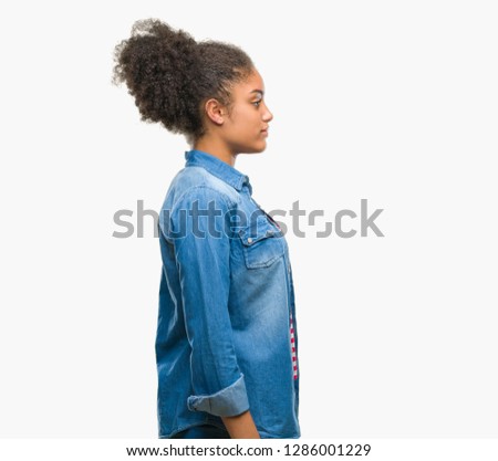 Young afro american woman over isolated background looking to side, relax profile pose with natural face with confident smile.