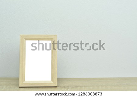 Wooden picture frame on timber deck and grey background with copy space for your text.