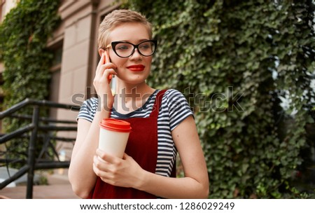 pretty woman in glasses outdoors talking on the phone