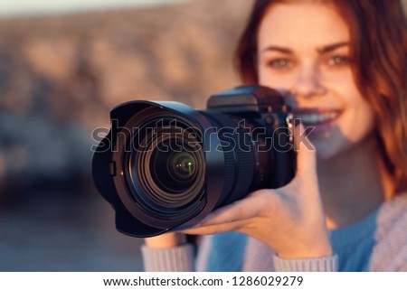 Pretty woman photographer with a camera in nature