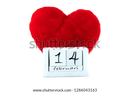 Wooden calender with the date of february 14th with a big red pillow heart behind it
