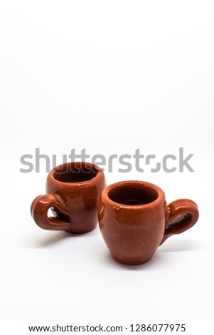 Two tiny iconic brown hot chocolate mugs isolated on a white background