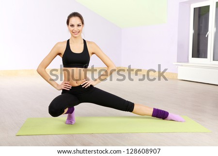 Young woman doing fitness exercises at gym