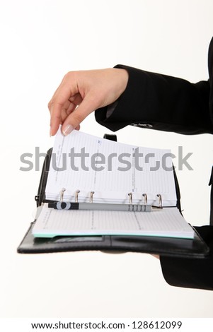 A cropped picture of a businesswoman holding  a planner.