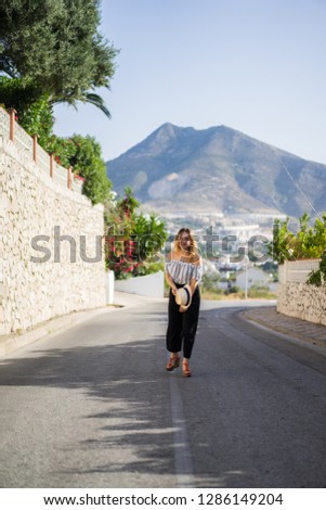 a young beautiful woman walks through the streets of a small European town. summer vacation