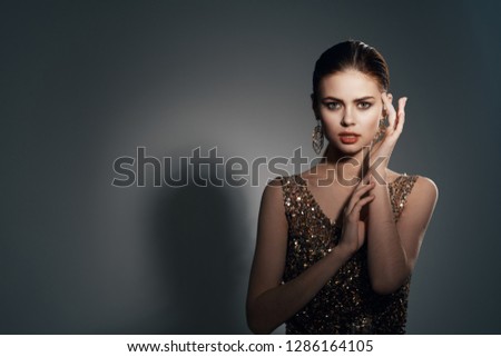 Elegant woman in an evening dress and with a beautiful make-up on her face                    