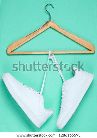 Flat Lay of Modern White Sneakers  Shoes With Hanger On Pastel Background. Overhead Top View Photography. Youth Lifestyle Concept