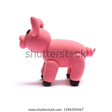 Cute pink pig of plasticine on a white background