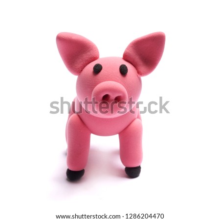 Cute pink pig of plasticine on a white background