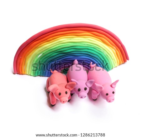 Pink pig of plasticine on a white background. Rainbow