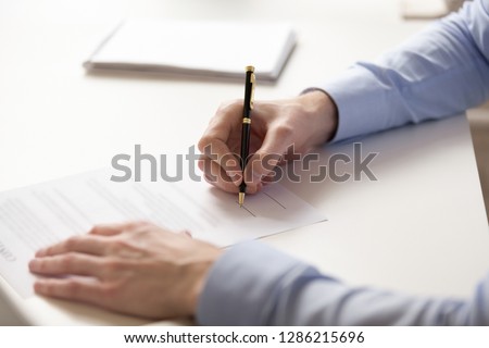 Close up businessman signing contract with pen, making legal deal, man putting signature to partnership agreement, accept conditions, working with business documents, paperwork, male hands view Royalty-Free Stock Photo #1286215696