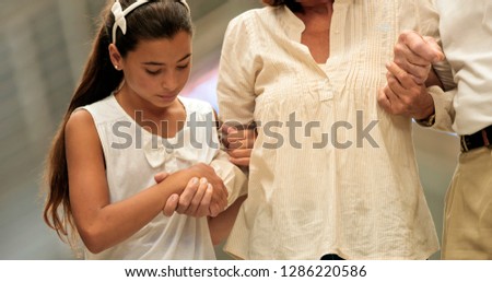Girl helping a woman to walk, holding her hand.